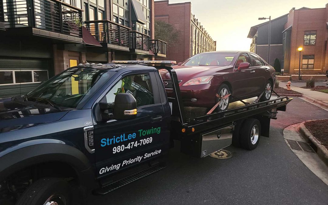 StrictLee Towing rollback truck loading a car in Huntersville NC
